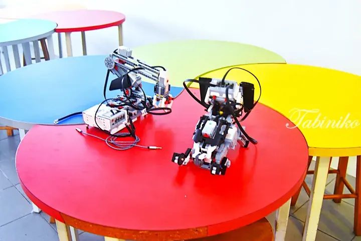 Two LEGO Mindstorms robots on a colorful round table, showcasing educational technology.