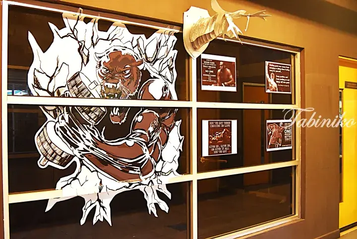 Gym window featuring a large black panther mural and motivational boxing posters.