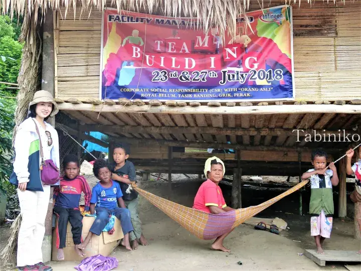 Woman and Orang Asli children at a team building CSR event in Royal Belum, Perak, Malaysia.