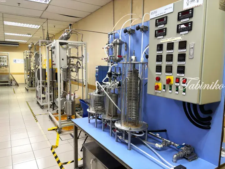 Laboratory setup featuring stainless steel bioreactors and a control panel with digital displays and switches.