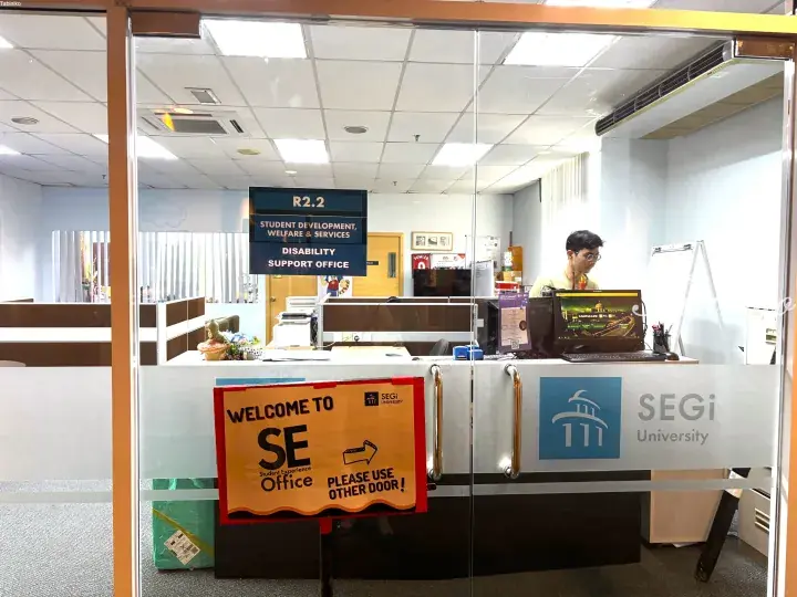 SEGi University’s Student Experience office entrance with a sign directing visitors to use another door.