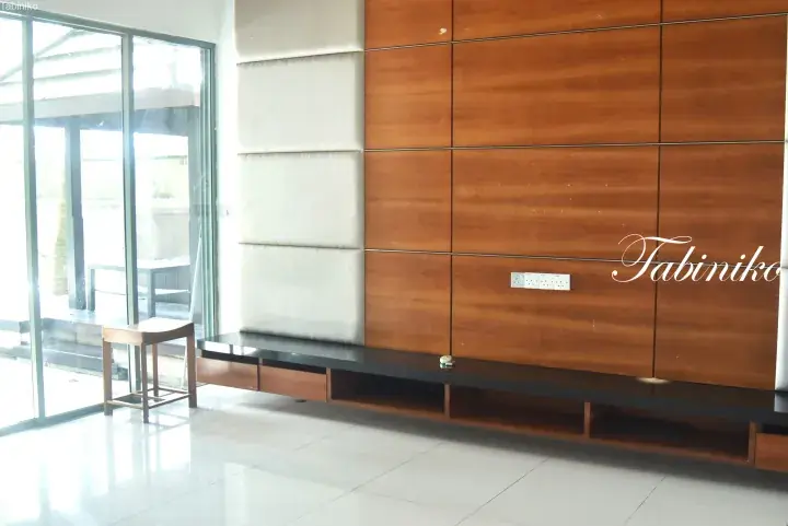 Modern living room with wooden panel wall, white padded accent, black TV console, and glass sliding doors.