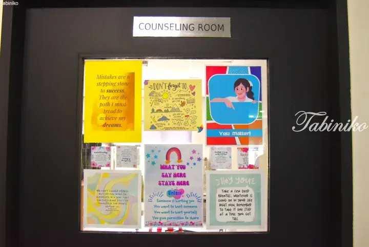 Counseling room door with motivational posters and quotes about kindness and self-care.