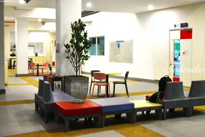 Modern university lounge with colorful modular seating, a display board, and a door labeled Science at KDU University College.