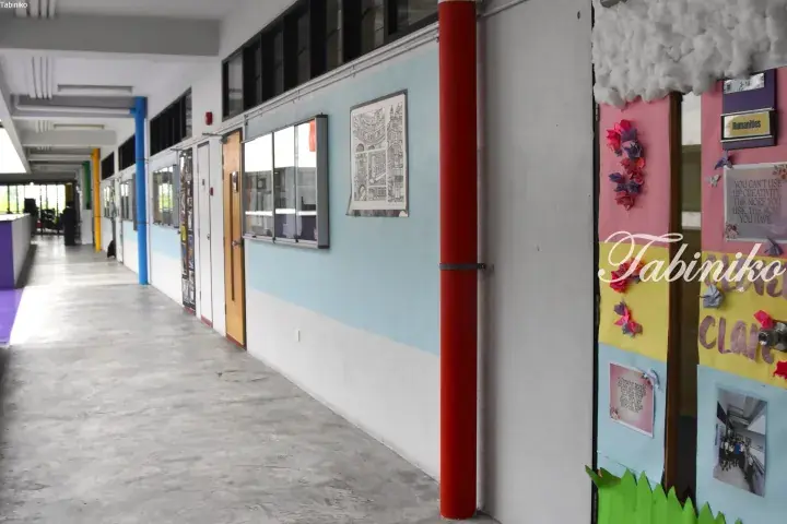 Colorful school corridor with student artwork and a red pillar.
