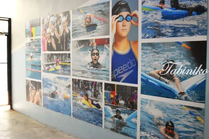 Wall collage featuring children swimming and playing in a pool with Speedo gear and Tabiniko watermark.