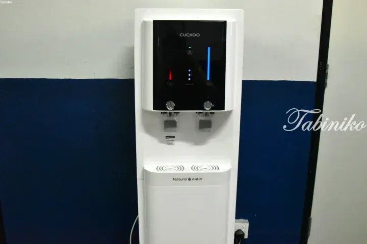 A white Cuckoo water dispenser with hot and cold options installed in a modern property.