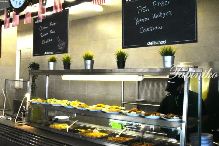 Buffet display at Delischool Malaysia featuring Asian dishes like Chicken Rose and Western options like Fish Finger.