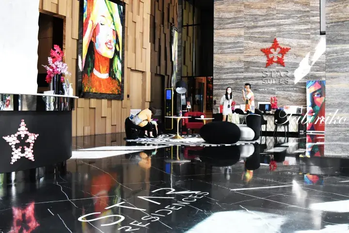 Modern lobby of Star Suites KLCC featuring a reception desk, contemporary art, and stylish seating area.