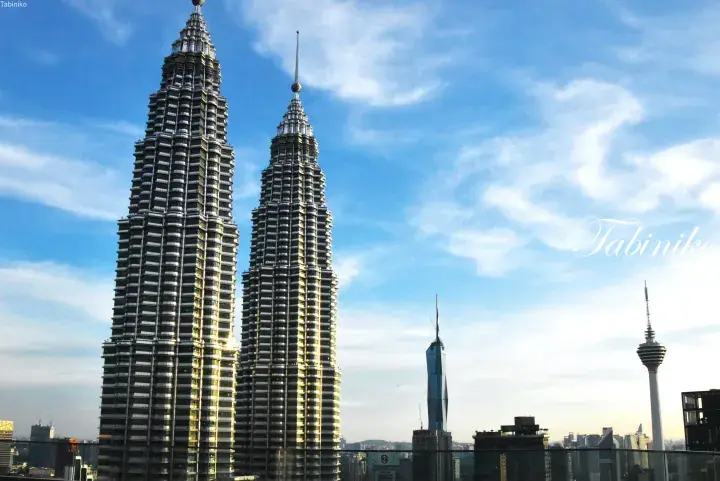 Petronas Twin Towers and Kuala Lumpur skyline at sunset with Merdeka 118 and KL Tower visible in the background.