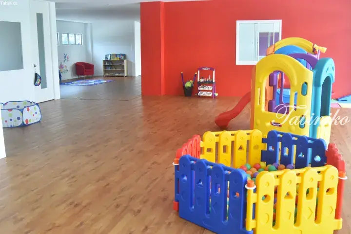 Colorful indoor play area with a ball pit and slide in a modern property, ideal for families.