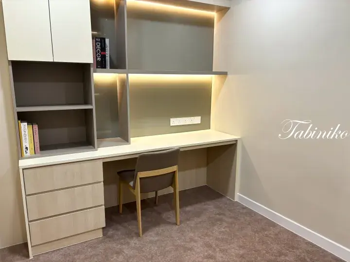 Modern built-in study desk with integrated lighting, shelving, and drawers in a minimalist room.