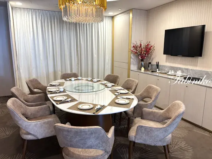 Luxurious dining room with a round table, crystal chandelier, and elegant decor.