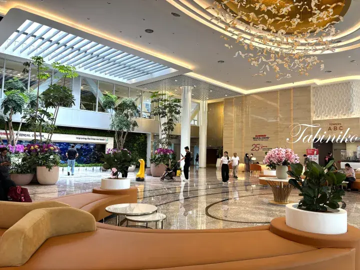Spacious lobby with modern chandelier, lush indoor plants, and seating area at Sunway Medical Centre.