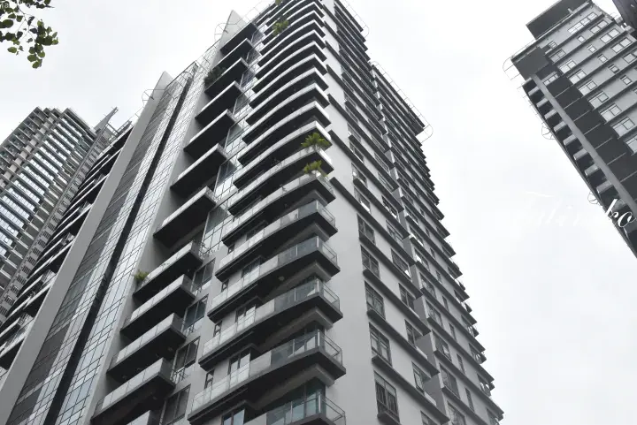 Low-angle view of modern high-rise condominiums with distinctive cantilevered balconies in a dense urban area