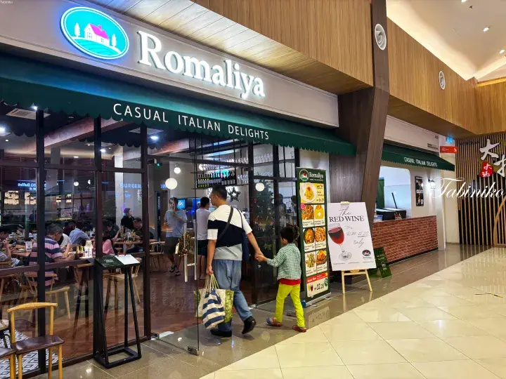 Romaliya Casual Italian Delights storefront at a shopping mall with customers entering and promotional signs outside.