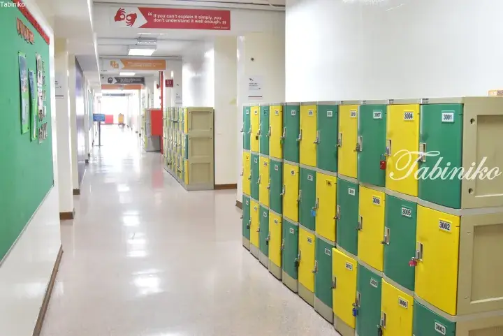 School hallway with green and yellow lockers and motivational quotes on the walls