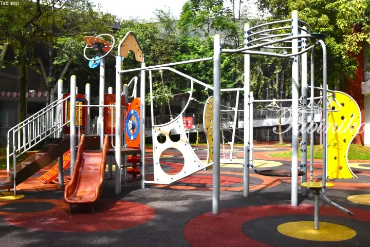 Colorful playground with slides and climbing structures on patterned rubber flooring at a Malaysia residential complex.