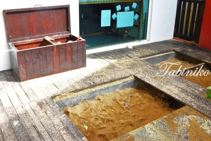 Outdoor play area with wooden sandbox and storage box at a property in Malaysia.