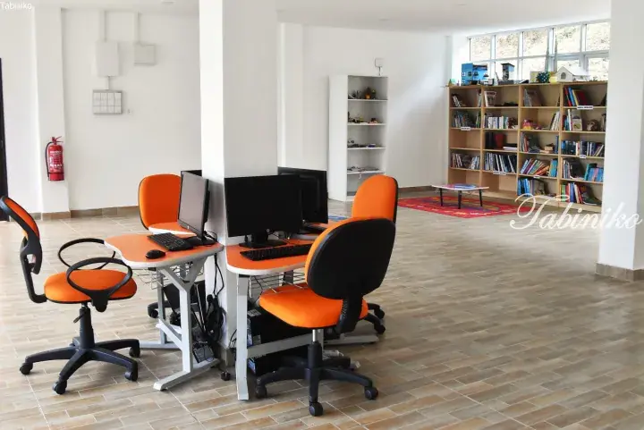 Bright computer lab with orange chairs and bookshelves in a modern Malaysian facility.