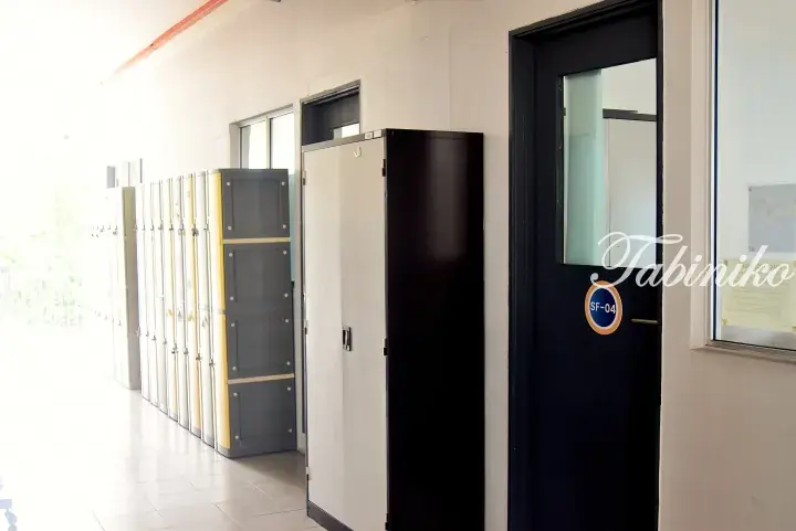 A hallway with rows of lockers and a black door labeled SF-04 at a property.