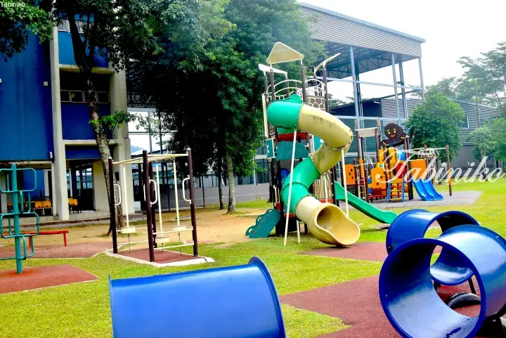 Colorful playground with slides and climbing structures at a residential property in Malaysia.