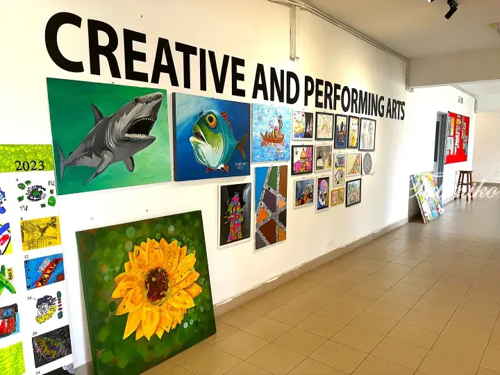 Hallway featuring a Creative and Performing Arts display with student paintings of a shark, fish, and sunflower.