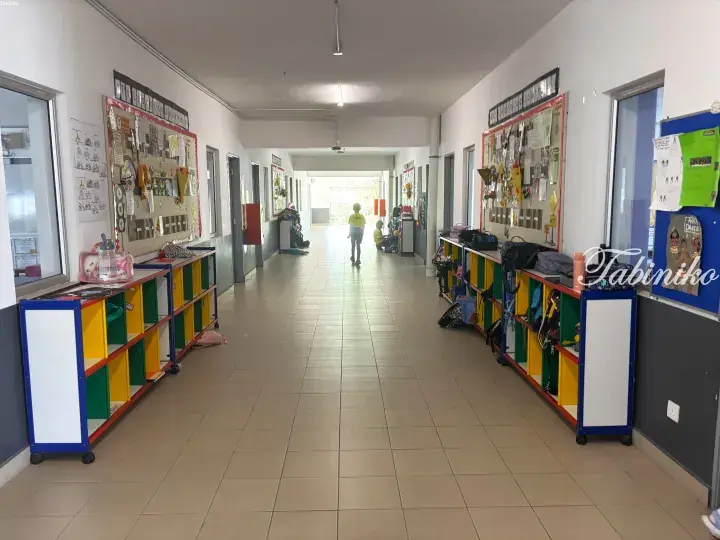 Bright school hallway with colorful student cubbies and bulletin boards displaying learning journeys