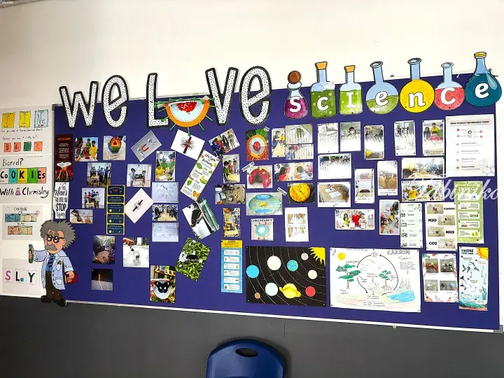 Classroom bulletin board displaying ‘We Love Science’ with student projects, photos, and educational posters.