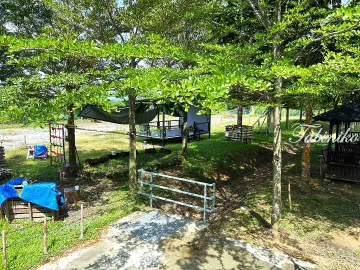 Shaded garden area with trees, a wooden gazebo, and a covered pavilion at a Malaysia property.