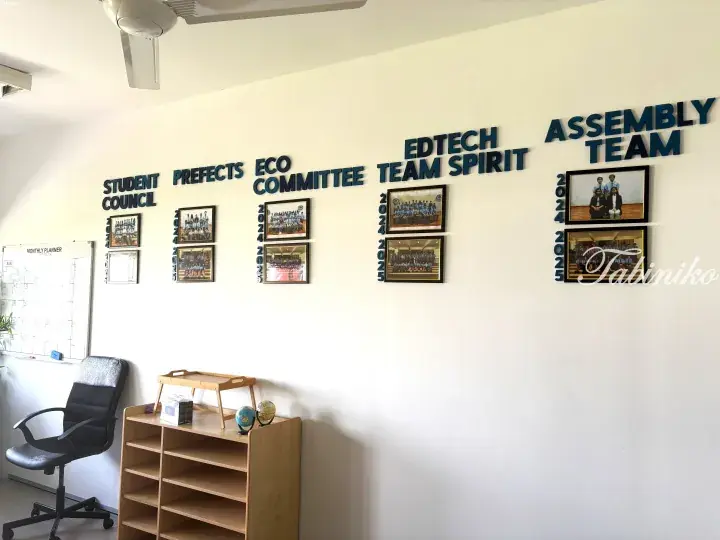 White wall displaying student council, prefects, eco committee, edtech, team spirit, and assembly team photos from 2024-2025.