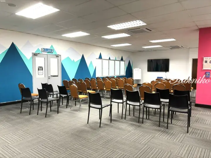Bright training room with mountain mural, rows of chairs, and KELUAR exit sign in Malaysia