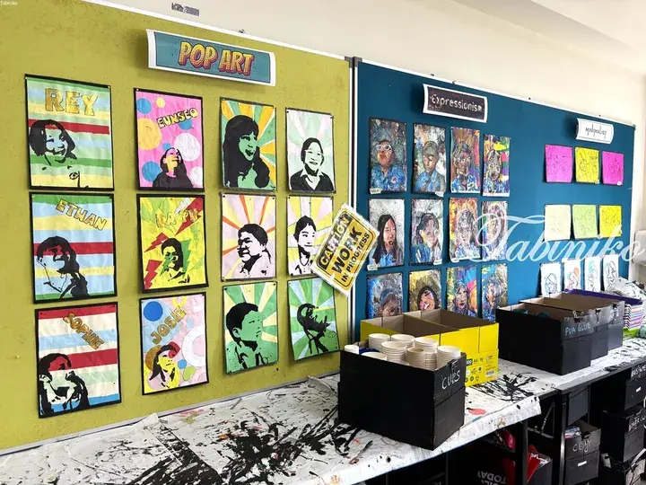 Classroom display featuring student art projects under Pop Art, Expressionism, and Minimalist art style headings.