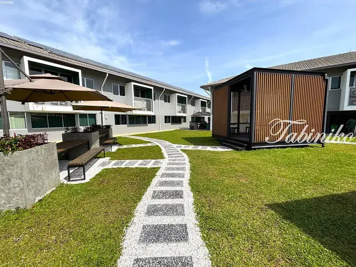 Modern residential courtyard with a winding stone path, green lawn, and a wooden slat gazebo.