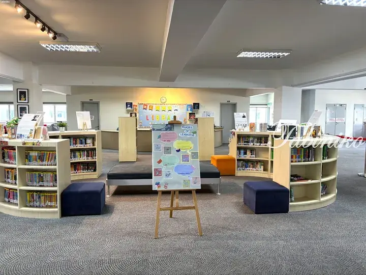 Bright school library with bookshelves, reading nooks, and a welcome sign.