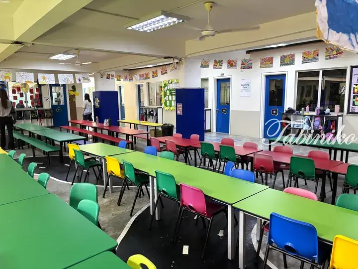 Colorful classroom with green tables and multicolored chairs in a Malaysian school.