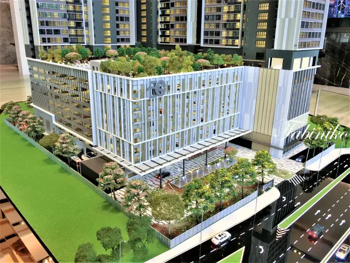 Architectural model of a modern residential complex featuring a multi-level car park with green rooftop garden and surrounding landscaping.