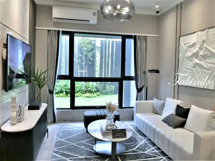 Modern living room with white sofa, marble coffee table, and large window overlooking lush greenery.