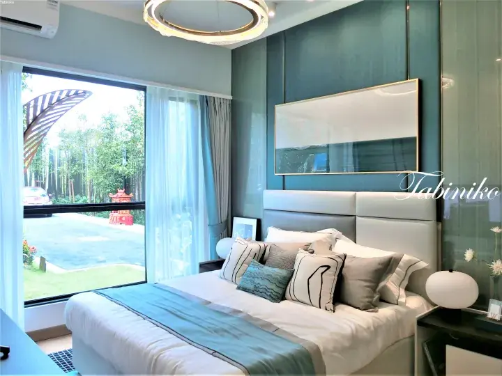 Modern bedroom with teal walls, white bed, and large window showing outdoor garden view.