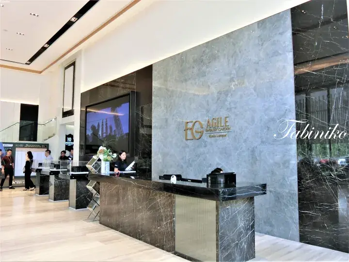Lobby reception of Agile Embassy Garden Kuala Lumpur featuring marble walls and a modern front desk.