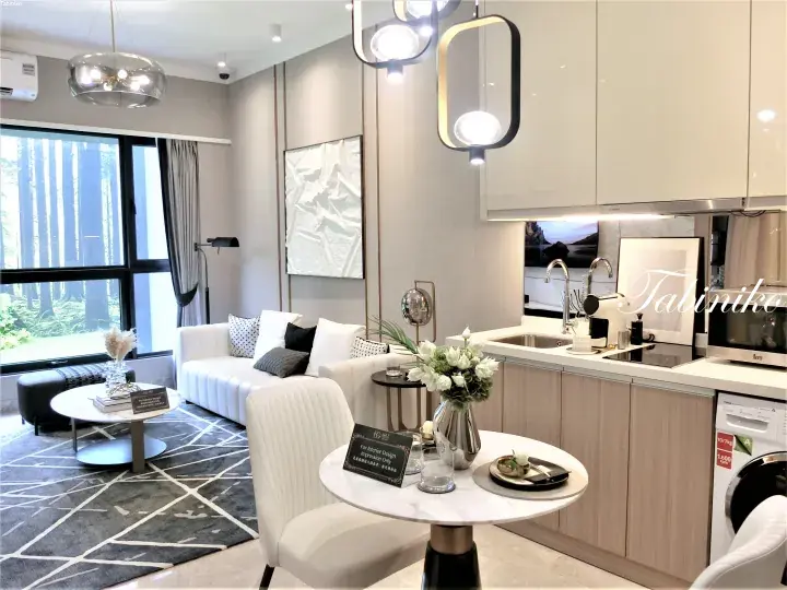 Modern open-plan living and kitchen area in a Malaysian property with white sofa, marble dining table, and forest view.
