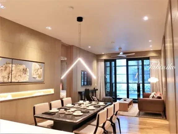 Modern dining room with marble table and V-shaped pendant light in a luxury Malaysian property.