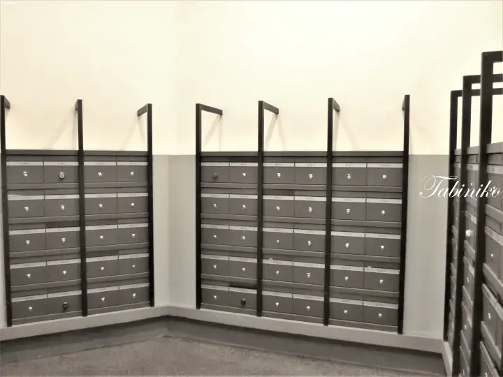 Modern grey mailboxes with black frames in a clean residential lobby.