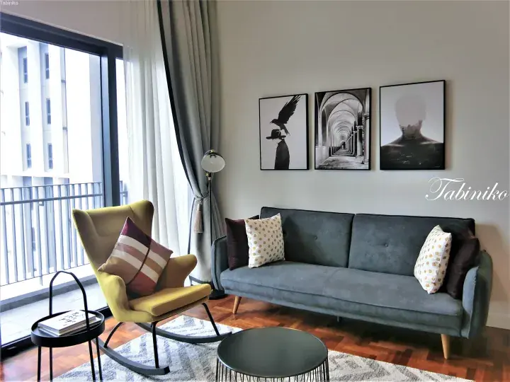 Modern apartment living room with grey sofa, yellow rocking chair, and balcony view