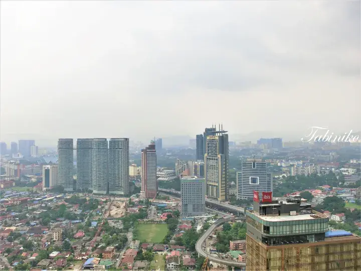 Kuala Lumpur skyline view featuring modern high-rise buildings, residential towers, and the ibis hotel sign.
