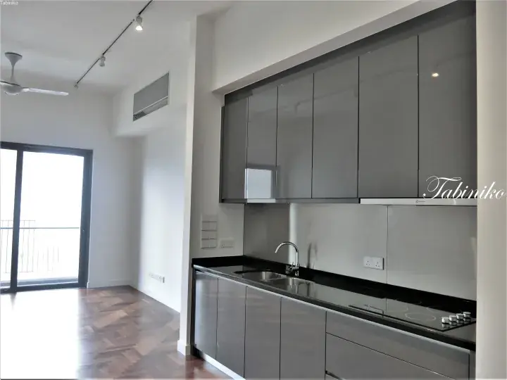 Modern kitchen with glossy grey cabinets, black countertop, and herringbone wood flooring in a Malaysian apartment.