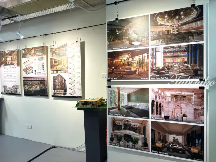 Interior design student project exhibition featuring architectural renderings, floor plans, and a scale model in a gallery setting.