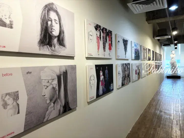Art gallery hallway displaying student sketches and fashion design portfolios with before-and-after comparisons.