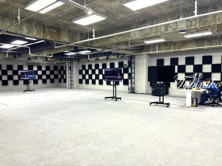 Modern motion capture studio in Malaysia with soundproof walls, cameras, and screens showing 3D character tracking.