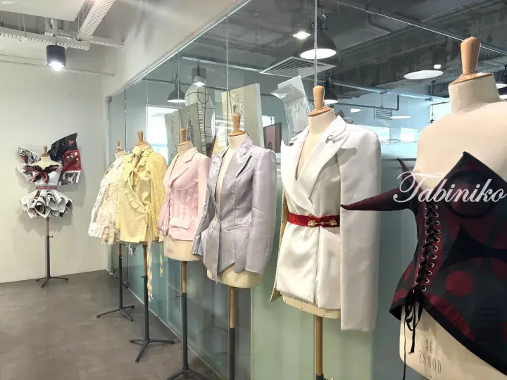 A row of mannequins displaying colorful fashion jackets and garments in a modern studio.